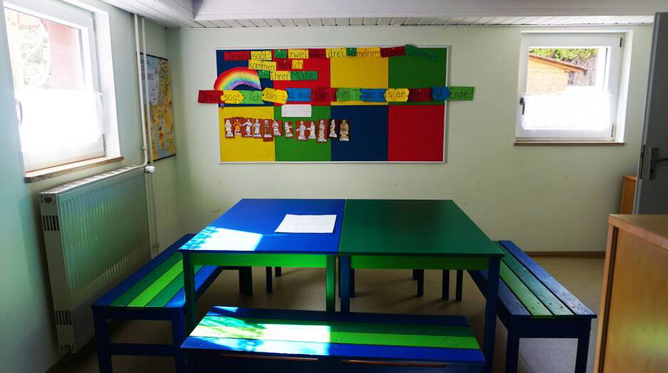 GH_Kinderraum-1 Blick in de Kinderraum im Gemeindezentrum, zwei Tische mit drei Bänken grün und blau