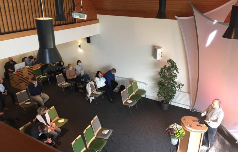 Bild in den Gottesdienstraum von oben, Am Sprecherpult steht Mike Milde