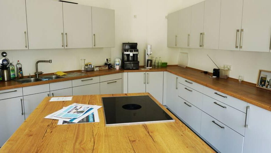 Küche im MGWH mit weissen Schränken und Holzarbeitsplatte, mit Kochinsel