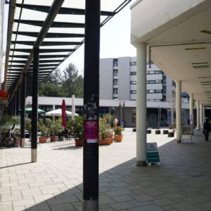 Gebäude am Einkaufszentrum Haderner Stern mit mehreren Säulen und, Blumenkübel